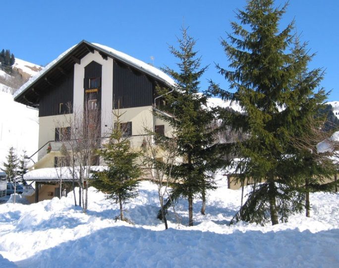 Le centre de vacances la chaudane sous la neige avec des sapins