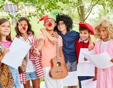 Des enfants déguisés tiennent des instruments de musique et se prennent en photo
