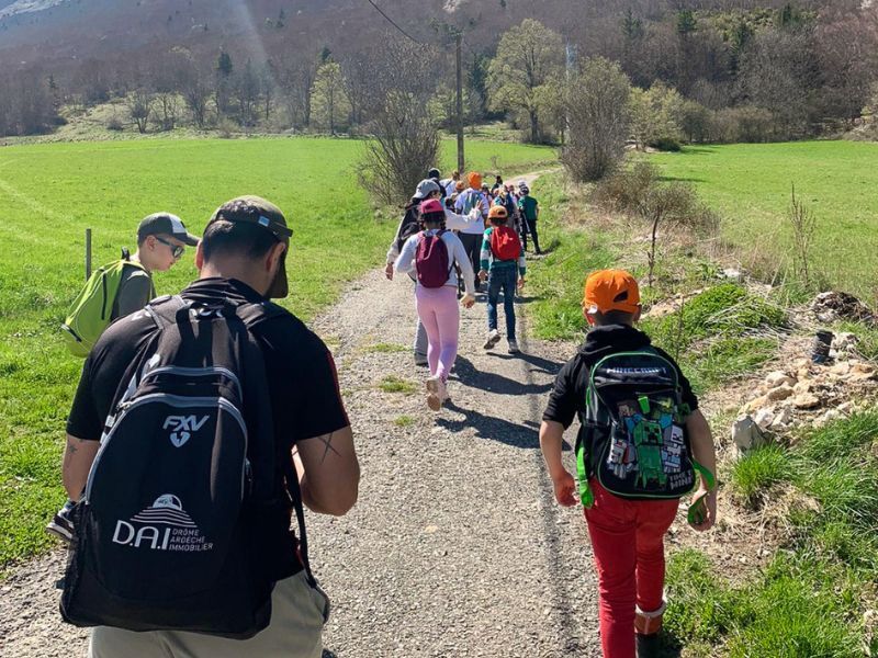 Des enfants font une randonnée dans la nature avec leurs animateurs de colonie