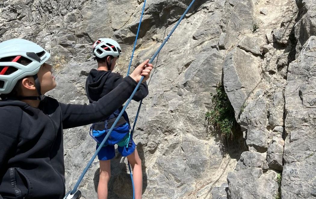 2 garçons qui grimpent une montagne en escalade