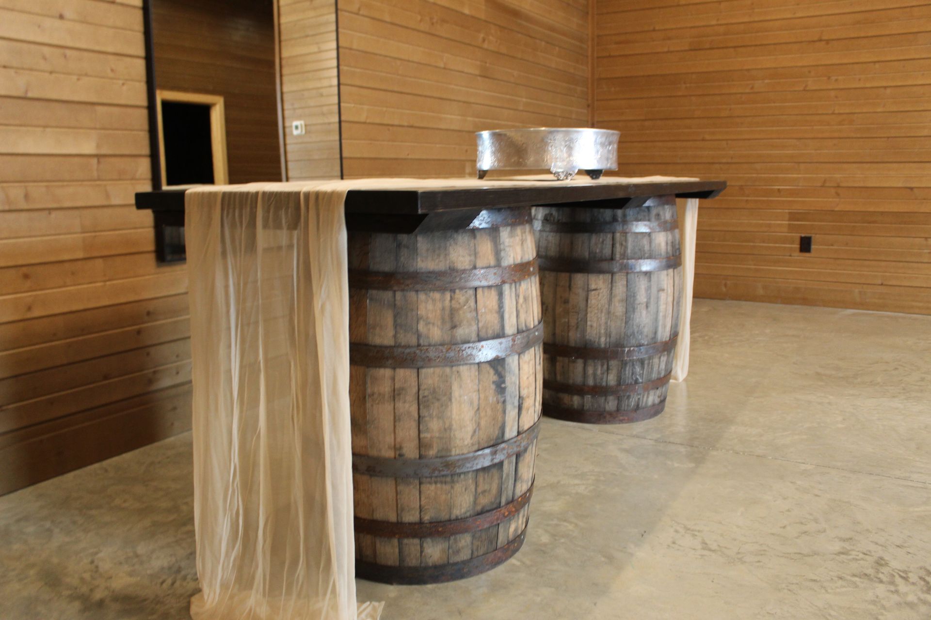 Two wooden barrels with a table top complete a serving table.