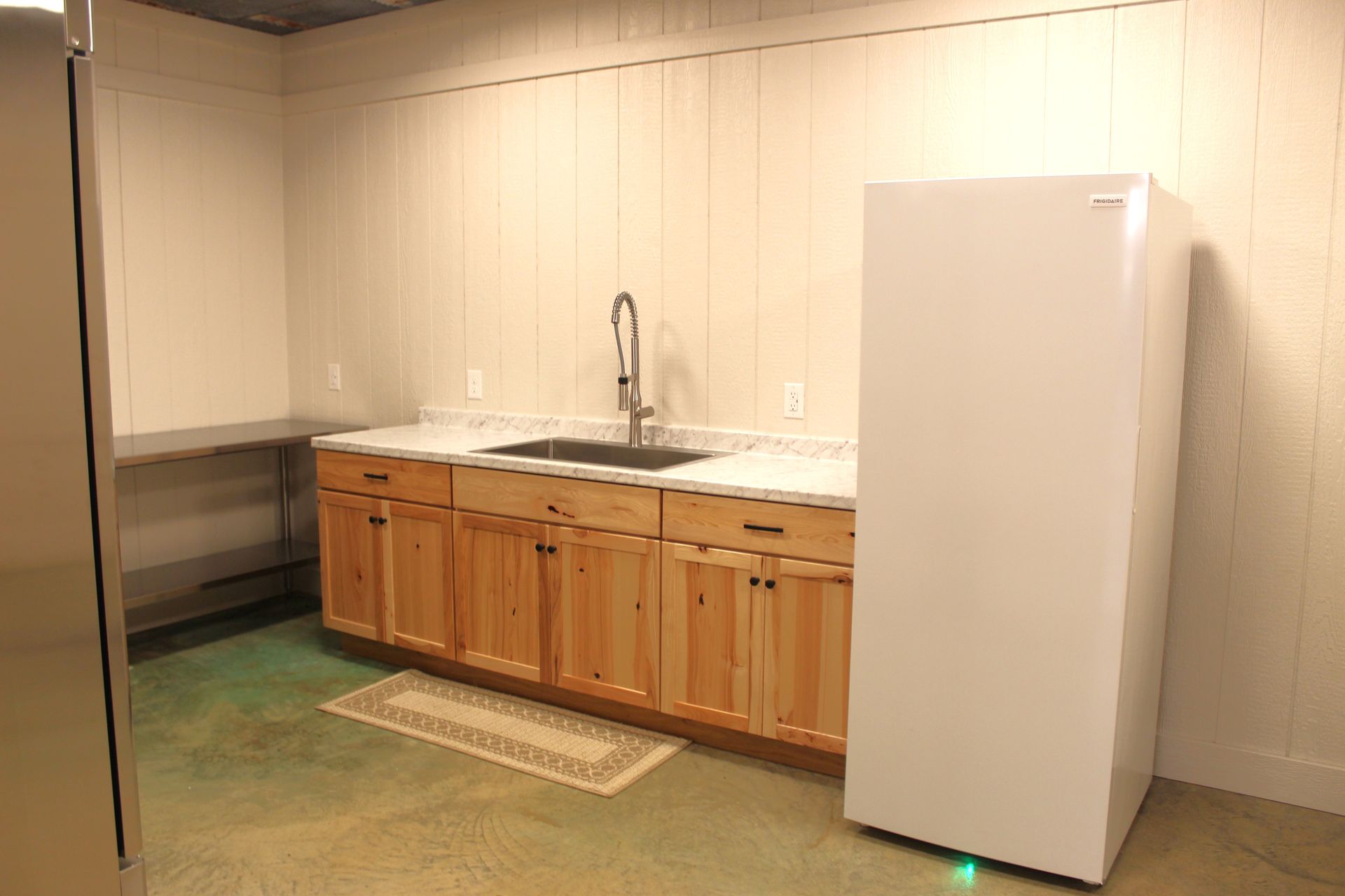 Kitchen features include stove, sink, freezer, industrial-size refrigerator, plenty of cabinet space, large industrial-sized warmer and 3 stainless steel prep tables.