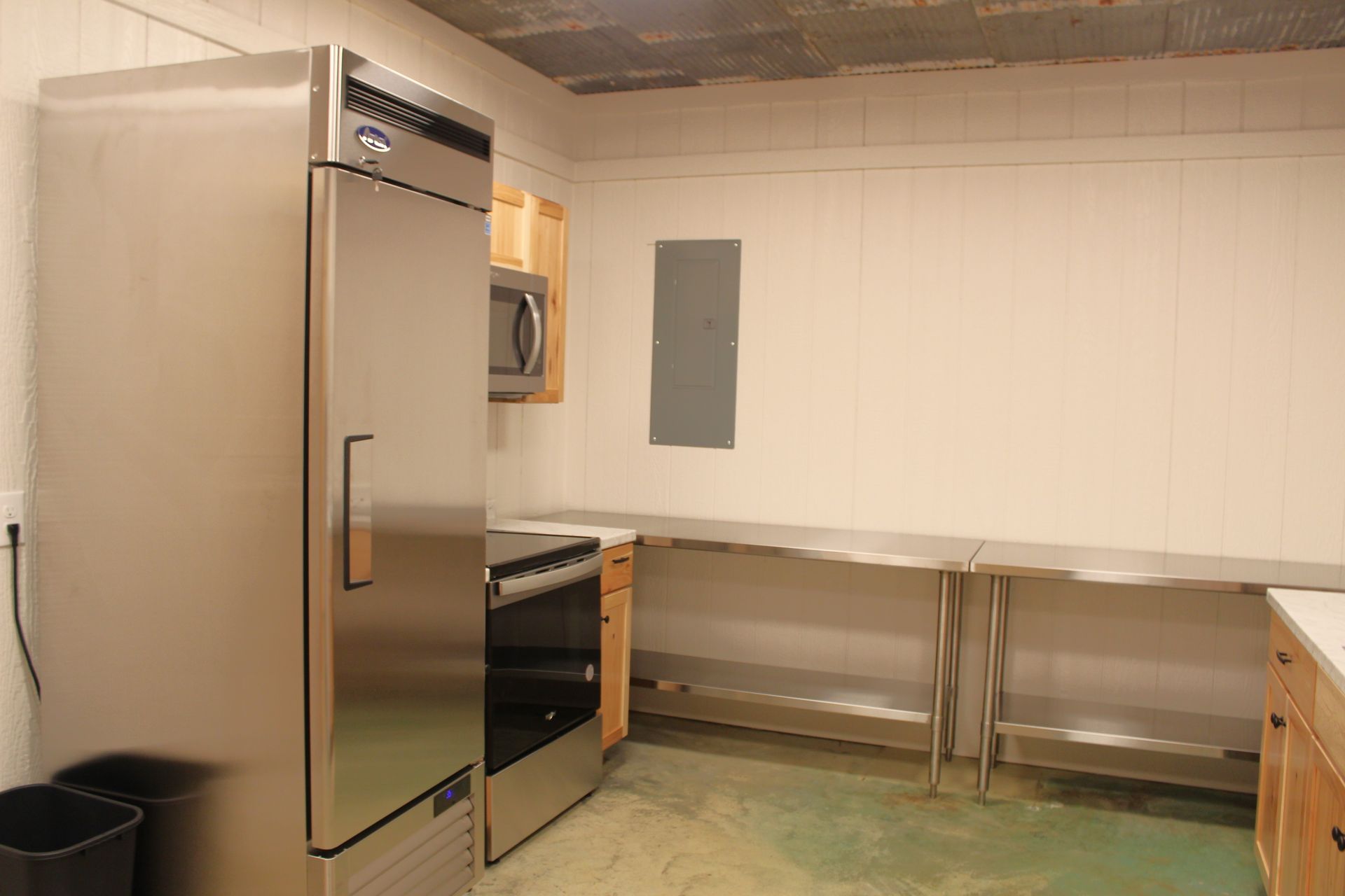 Kitchen features include stove, sink, freezer, industrial-size refrigerator, plenty of cabinet space, large industrial-sized warmer and 3 stainless steel prep tables.