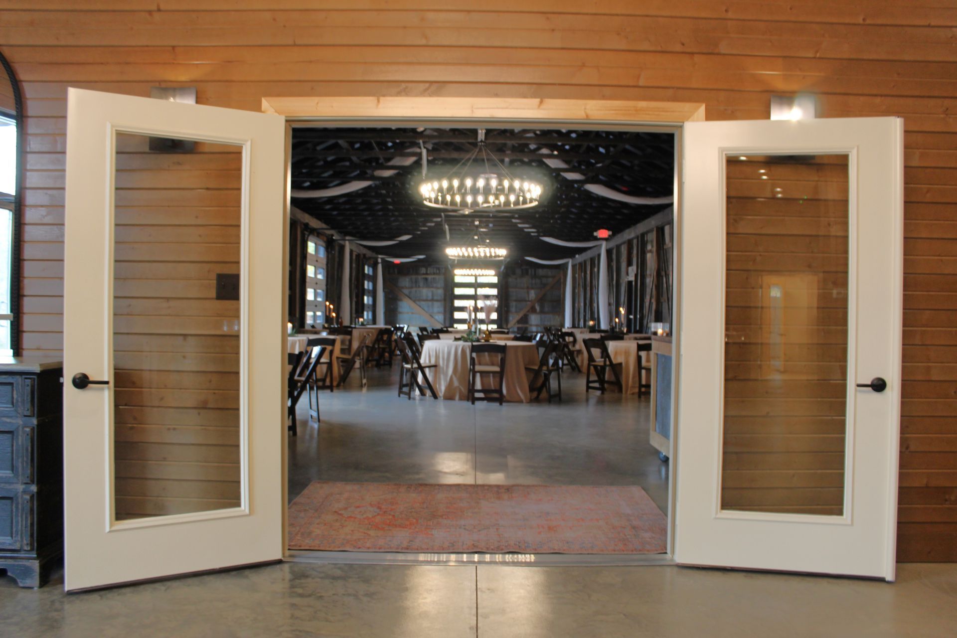The doors are open to a large room with tables and chairs.