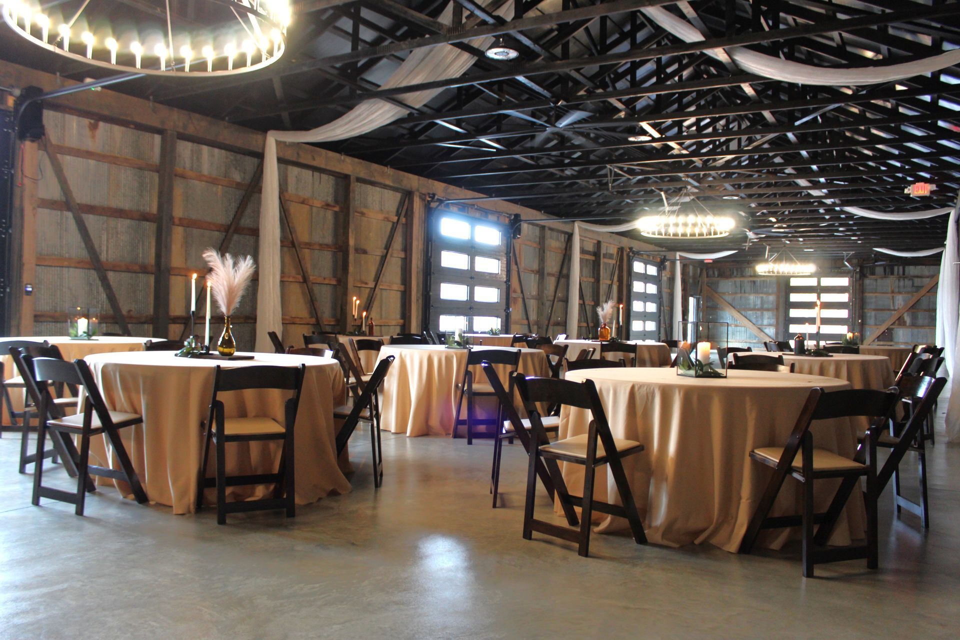 A large room with tables and chairs set up for a wedding reception.