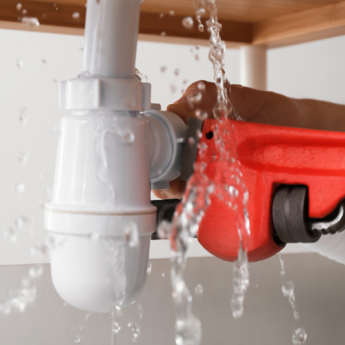 A person is fixing a sink drain with a plunger