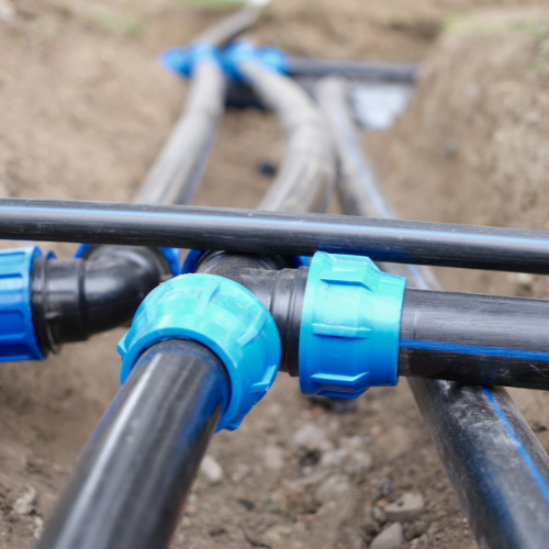 A bunch of black pipes with blue caps on them