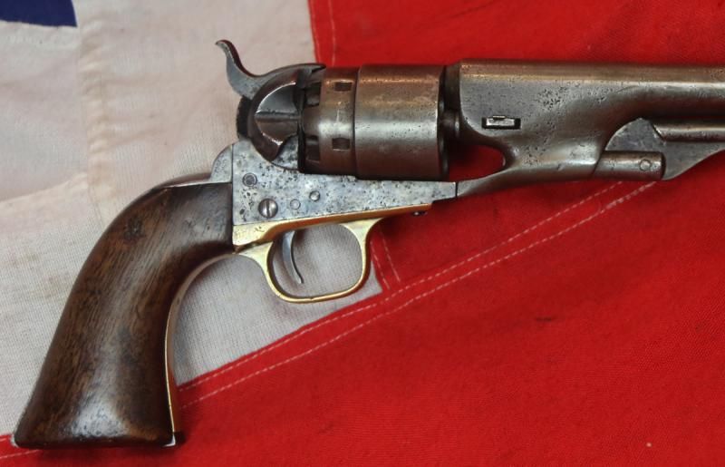 Original Colt revolver with a wooden grip and brass trigger.