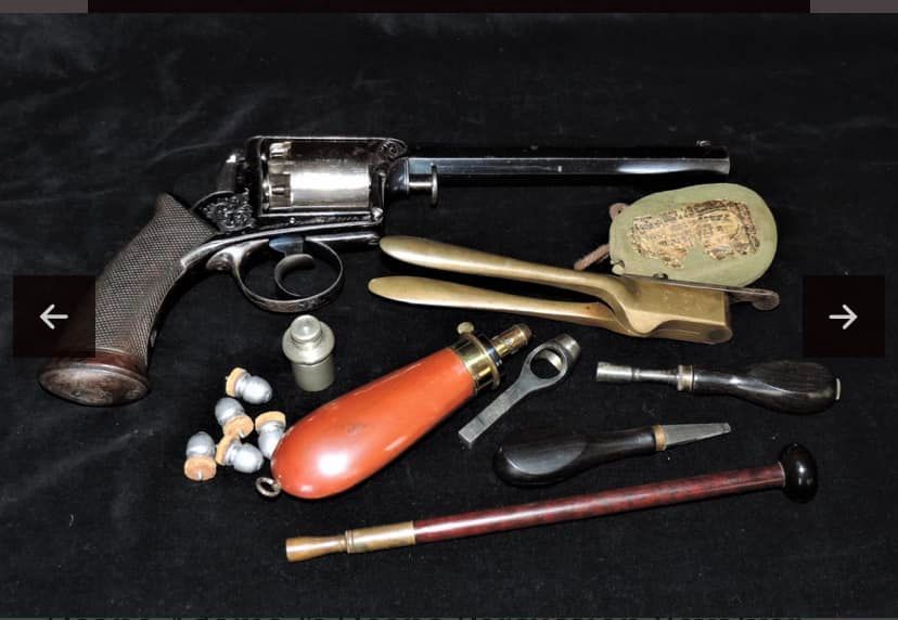 a revolver is surrounded by tools and bullets on a table