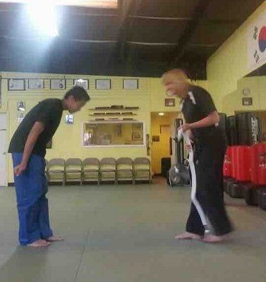 Two people bowing in a martial arts studio.