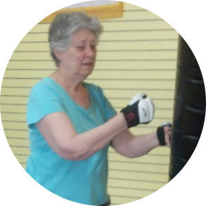 Woman in blue shirt boxing a punching bag. Woman in blue shirt boxing a punching bag.
