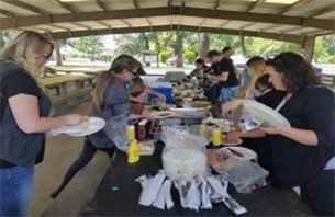 People at a picnic table under a covered pavilion. People at a picnic table under a covered pavilion.