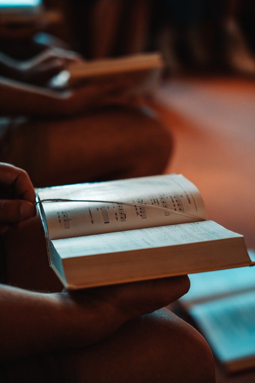 A person is sitting on the floor reading a book.