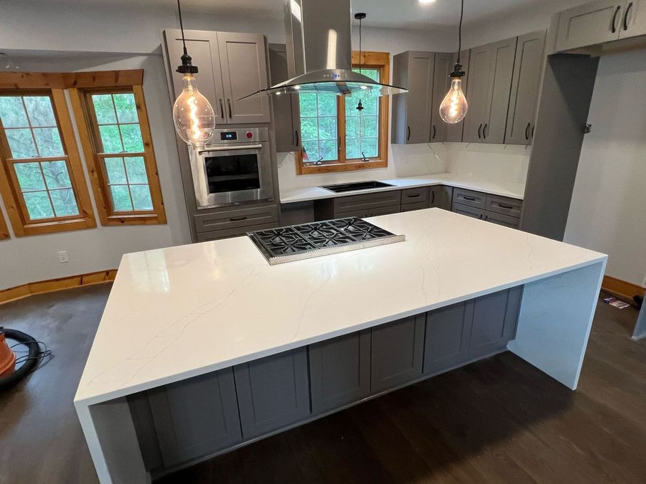 A kitchen with a large island and a stove top oven.