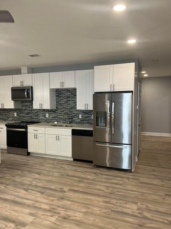 A kitchen with stainless steel appliances and white cabinets