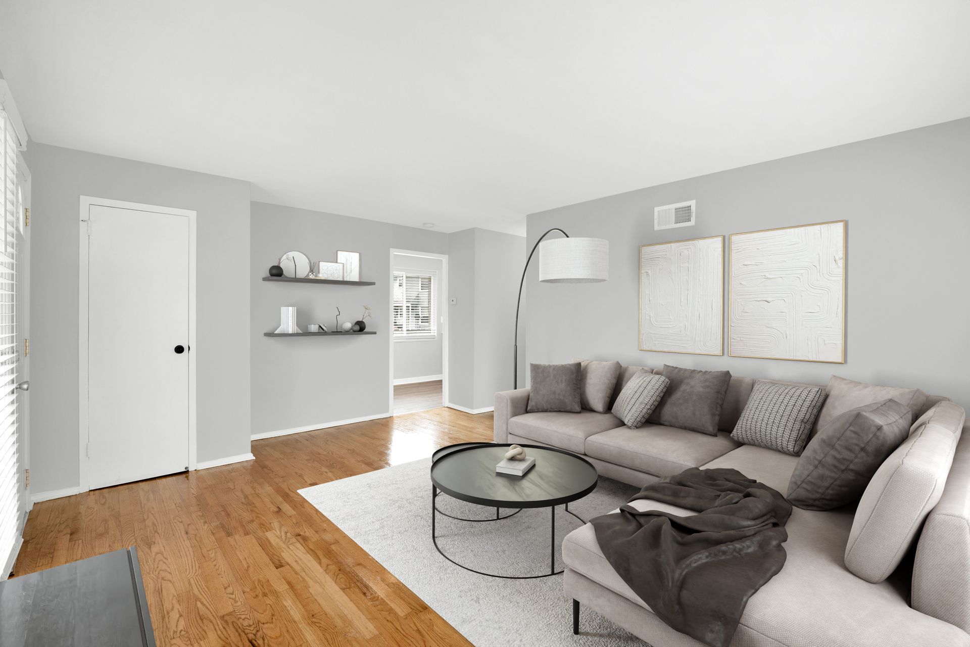 Living room with gray walls, a sectional sofa, and hardwood floors.