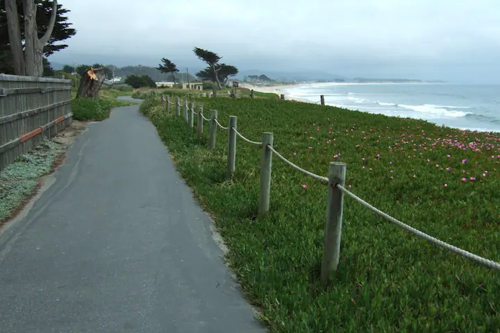 Paved walking path along the coast which is a part of Half Moon Bay Coastral Trail. Cloudy sky. Ocean view.