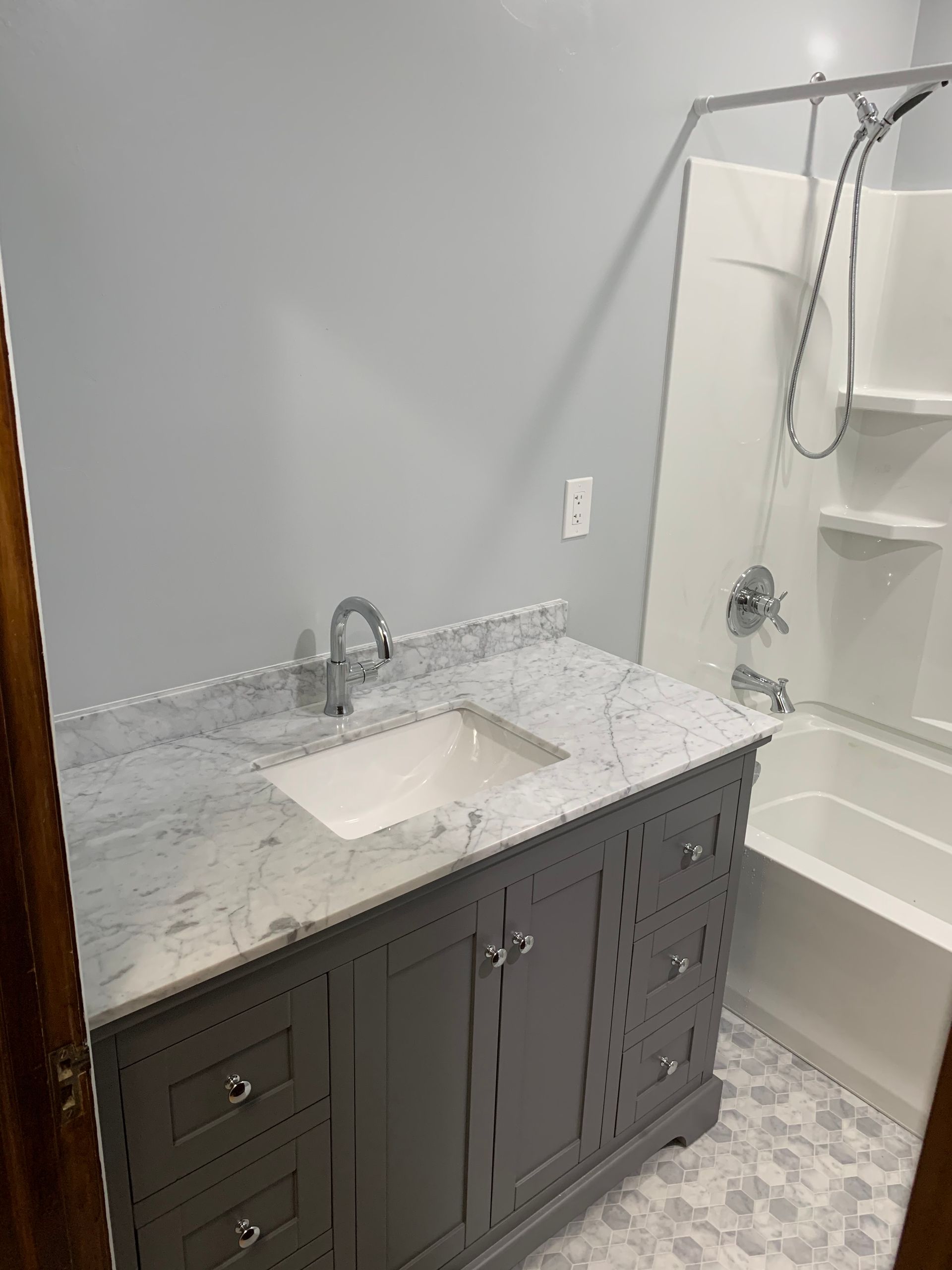 A bathroom with a sink , tub and shower.