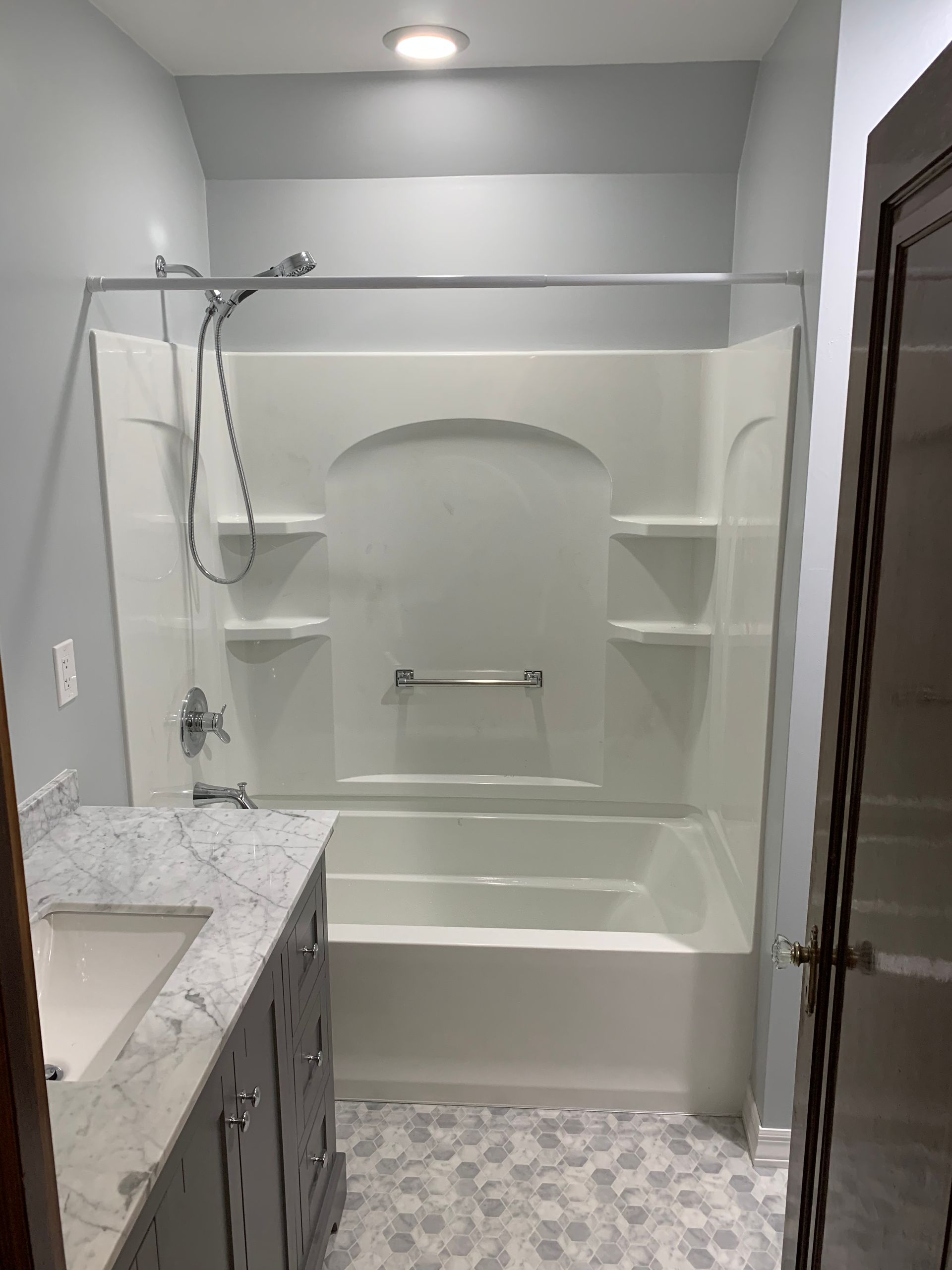 A bathroom with a bathtub , sink and shower.