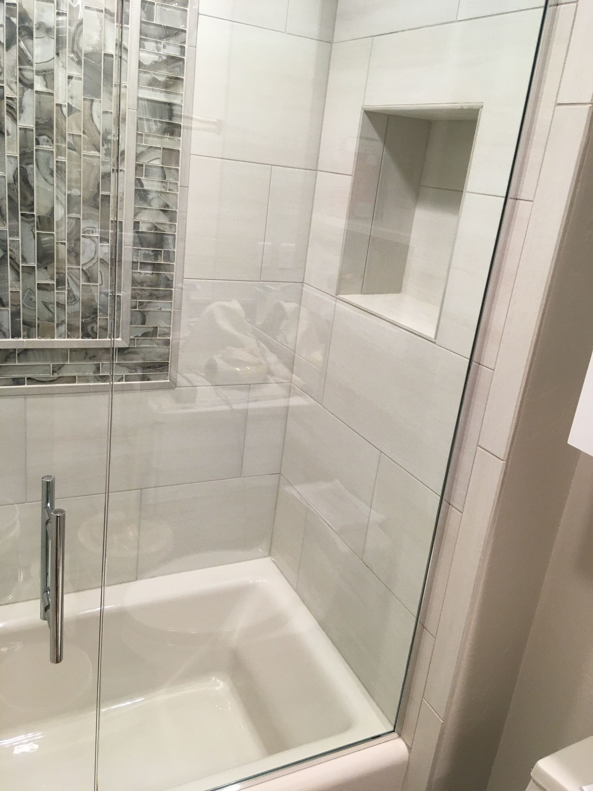 A bathroom with a tub and a shower with a glass door.