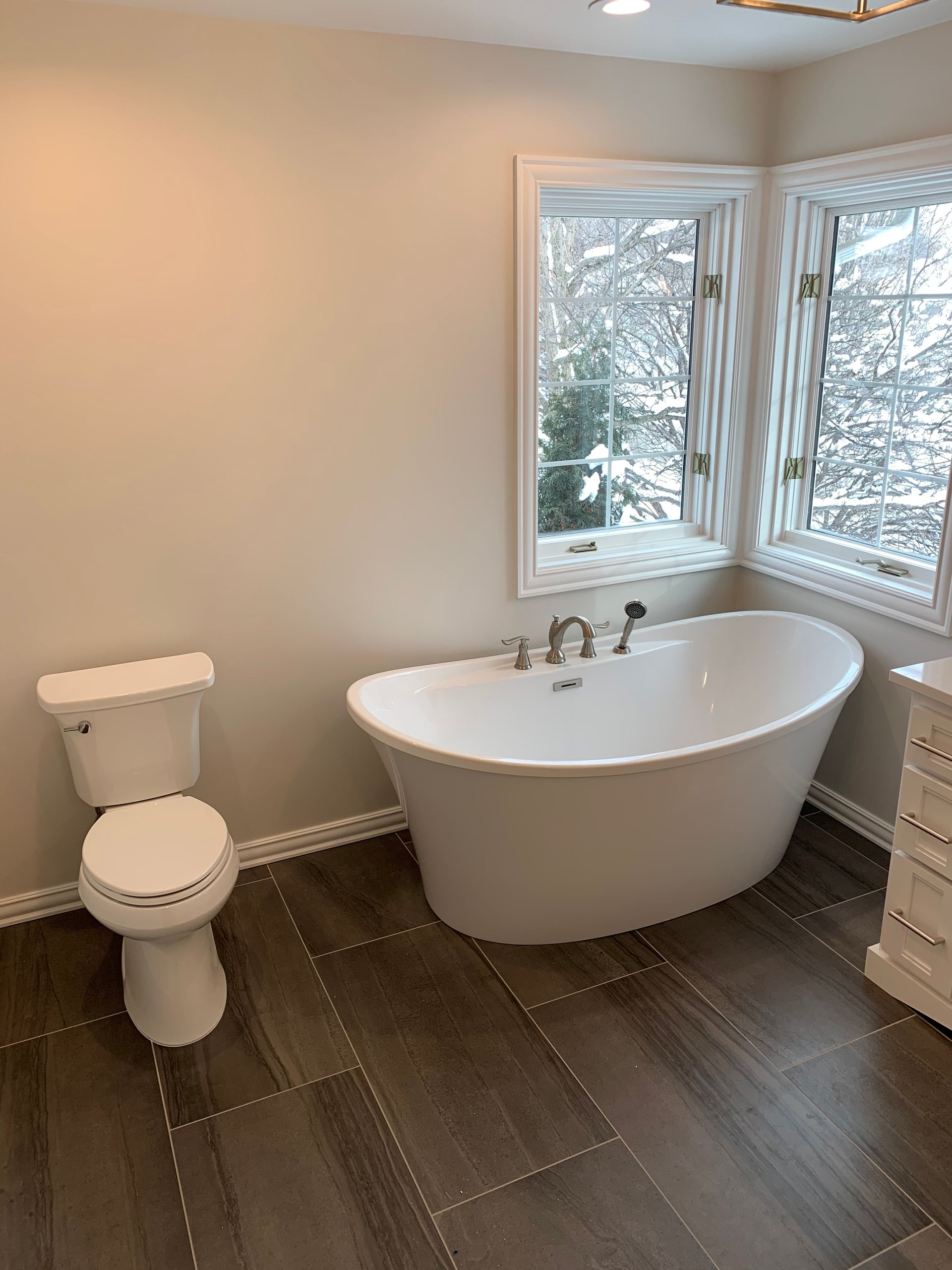 A bathroom with a tub , toilet and window.