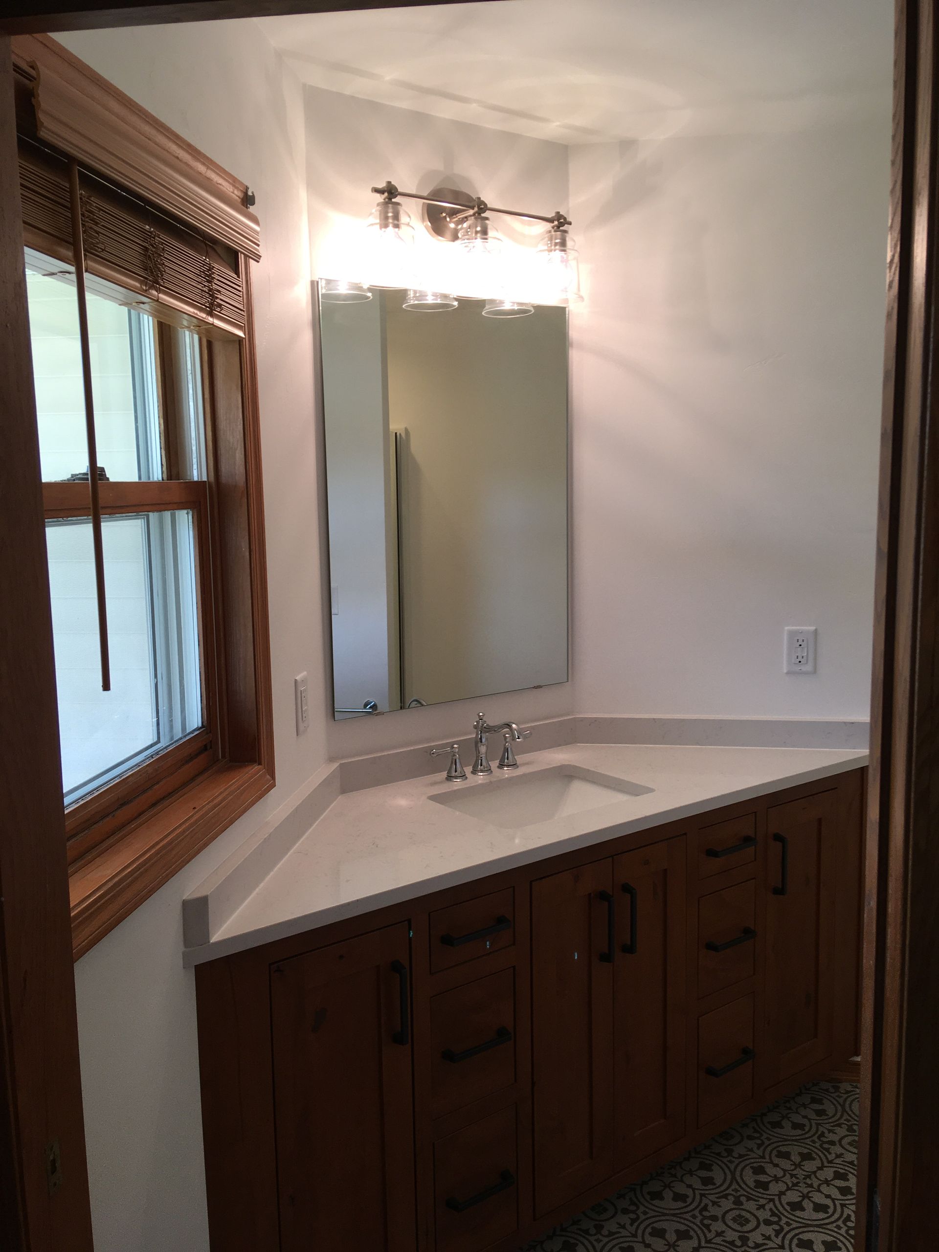 A bathroom with a sink a mirror and a window