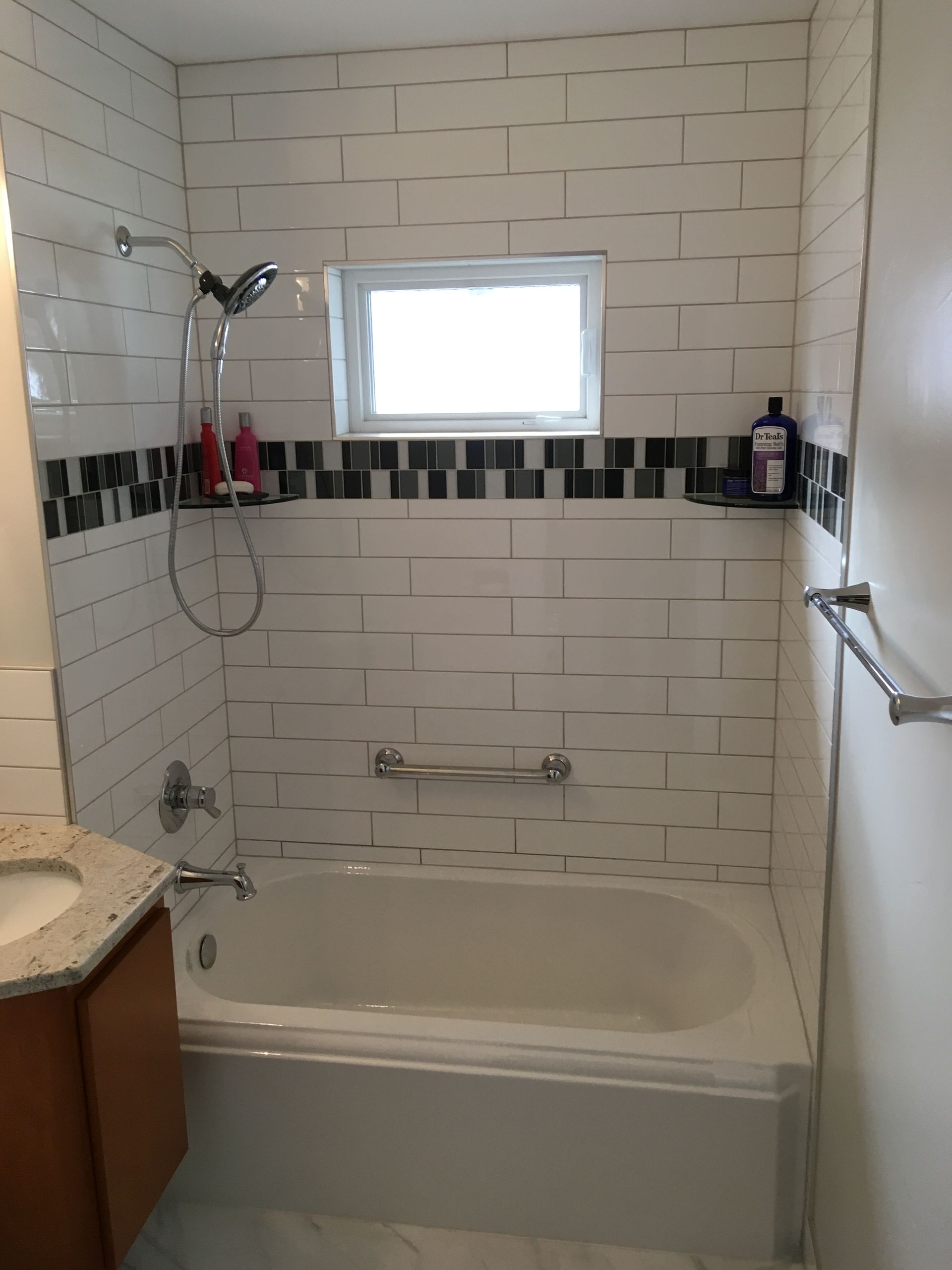 A bathroom with a bathtub and a window