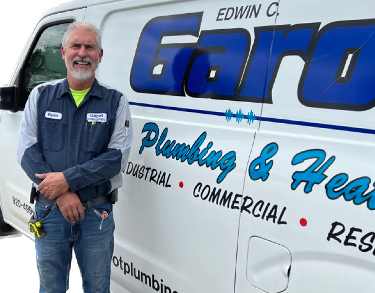 A man is standing in front of a garo plumbing and heating van.