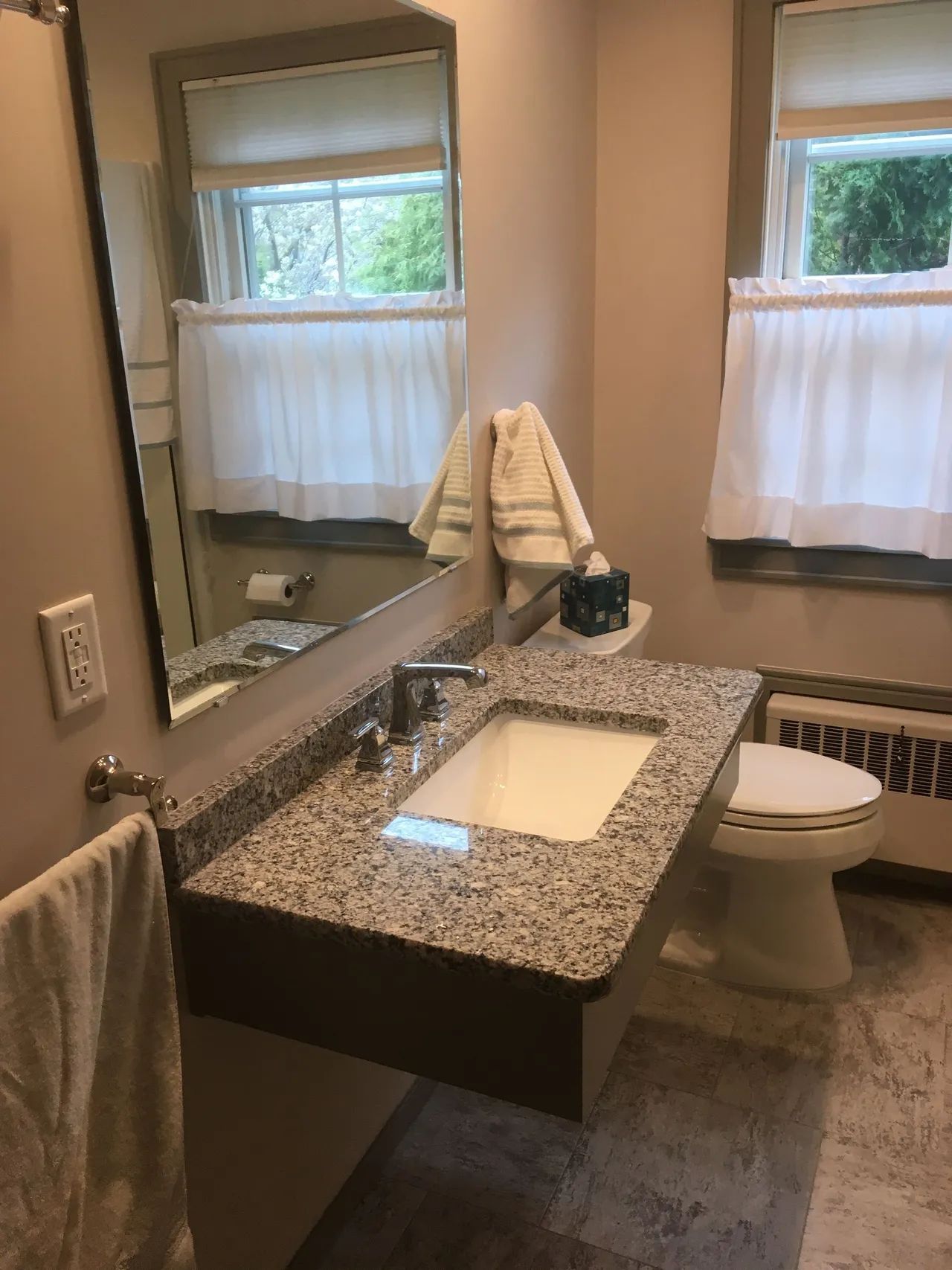 A bathroom with a sink , toilet and mirror
