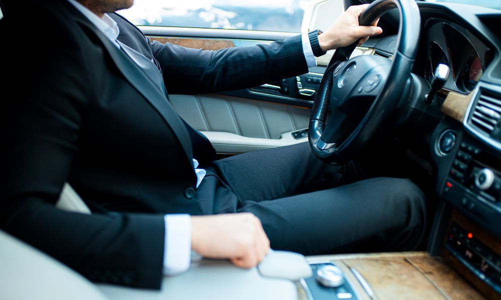 A man in a suit is driving a car.