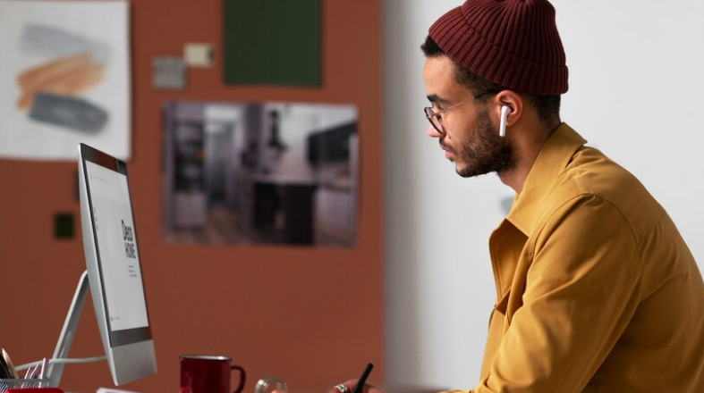 A man is sitting at a desk in front of a computer.
