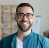 A man with a beard and glasses is smiling for the camera.