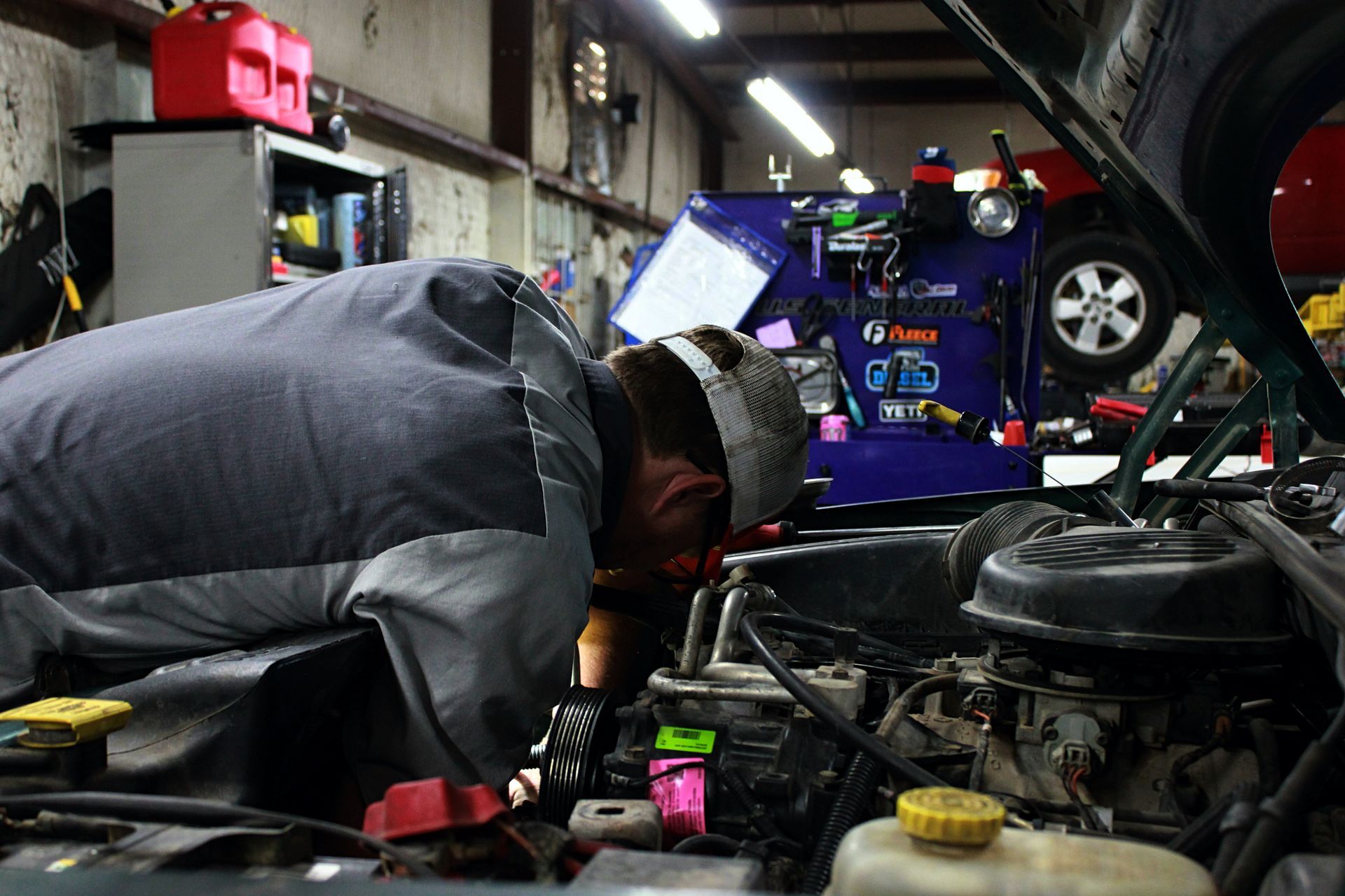 Mechanic working on a car engine in a garage.