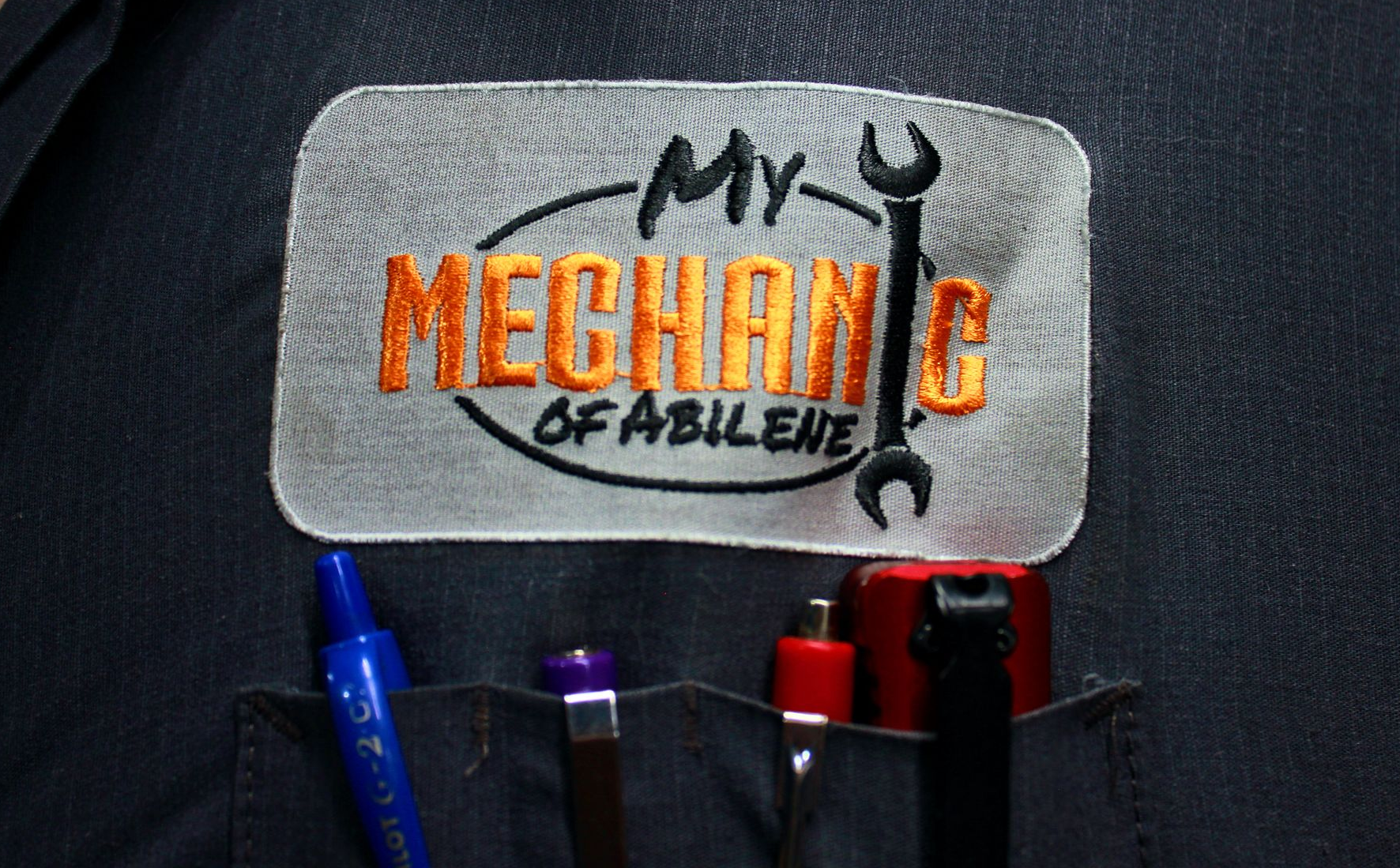 Patch on a mechanic's pocket reading