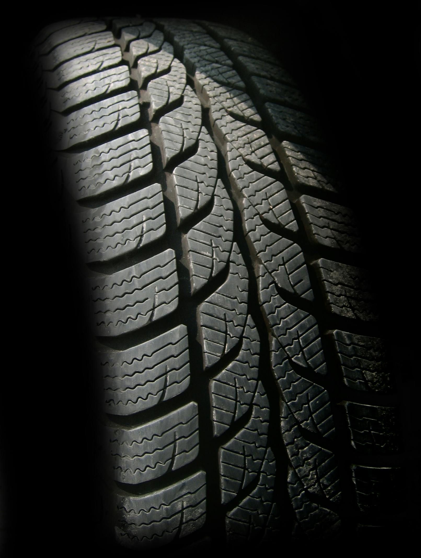 Close-up of a black tire with a textured tread pattern.