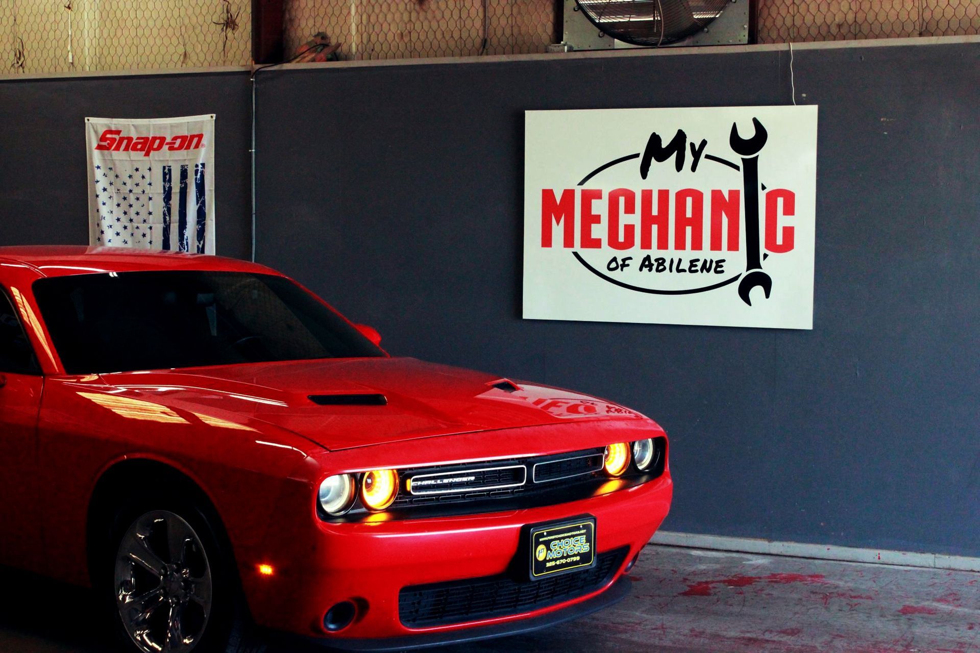 Red Dodge Challenger car in a garage with a
