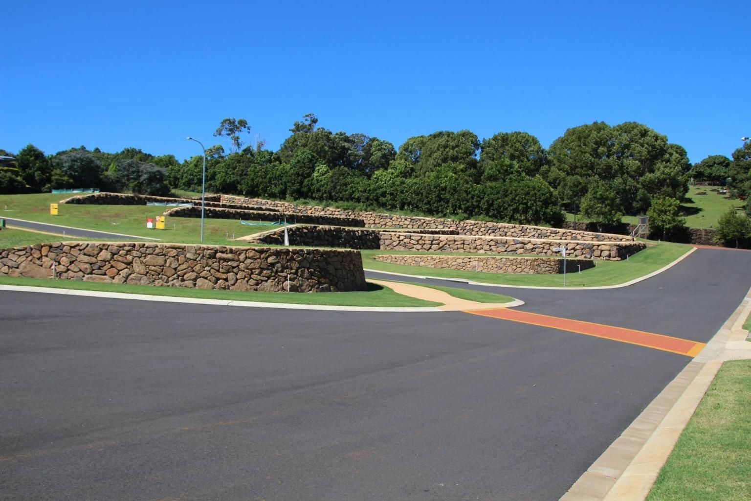 A Road With A Stone Wall On The Side Of It — Australian Rock Walls In Burleigh Heads, QLD