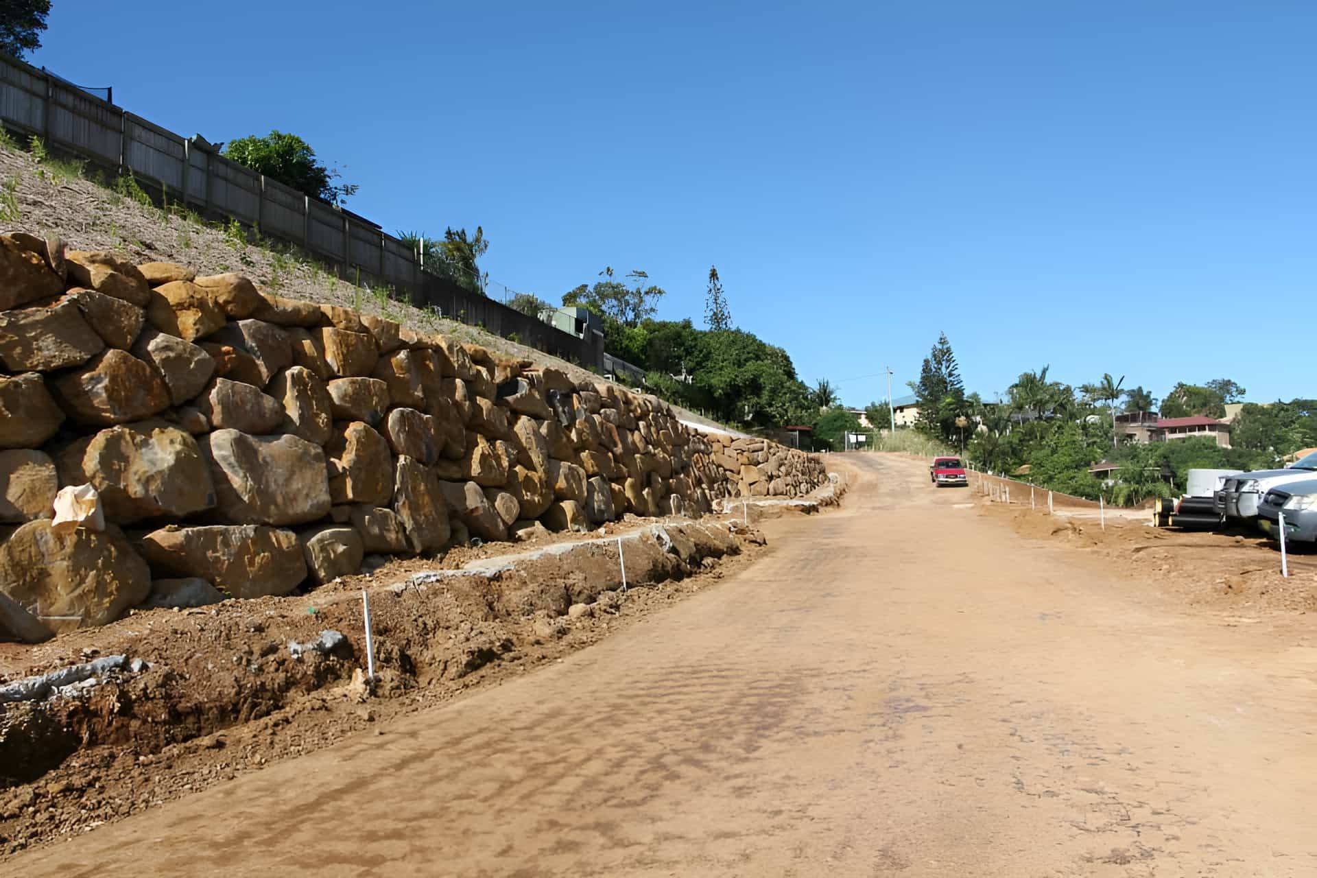 A Dirt Road With A Rock Wall On The Side Of It — Australian Rock Walls In Burleigh Heads, QLD