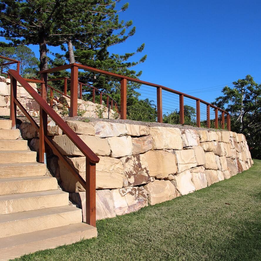 Stairs leading up to a stone wall with a wooden railing — Australian Rock Walls In Burleigh Heads, QLD