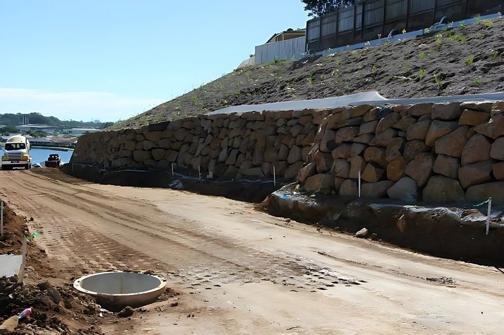 A Dirt Road with a Large Stone Wall in the Background