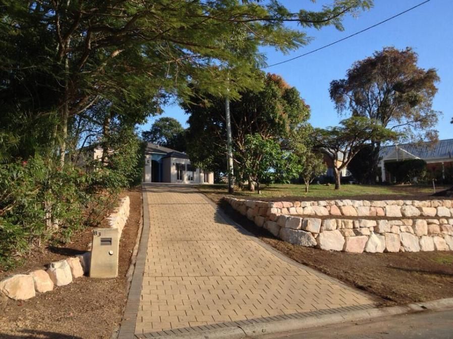 A Brick Driveway Leading To A House With Trees On Both Sides — Australian Rock Walls In Burleigh Heads, QLD