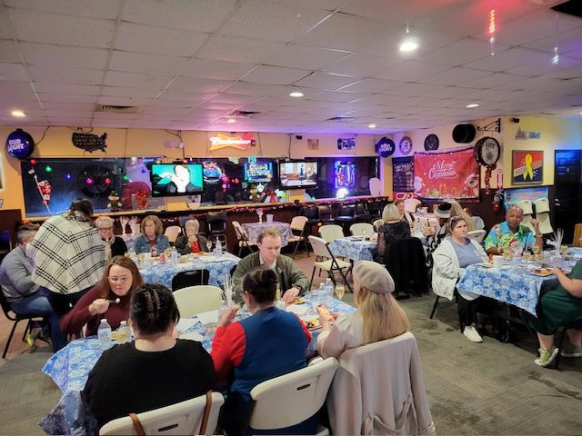 A group of people are sitting at tables in a restaurant.