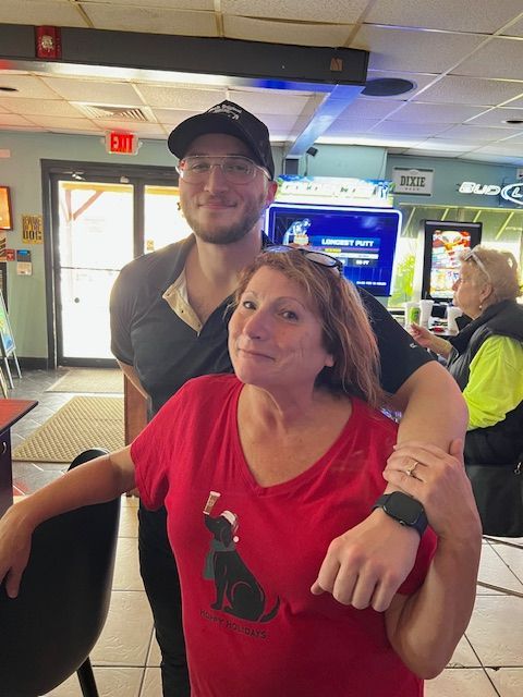 A man and a woman are posing for a picture in a restaurant