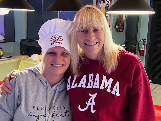 Two women wearing alabama shirts are posing for a picture