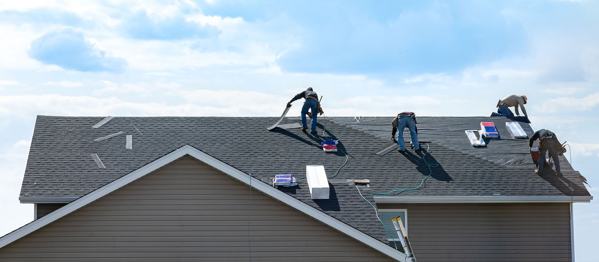 A group of men are working on a roof.