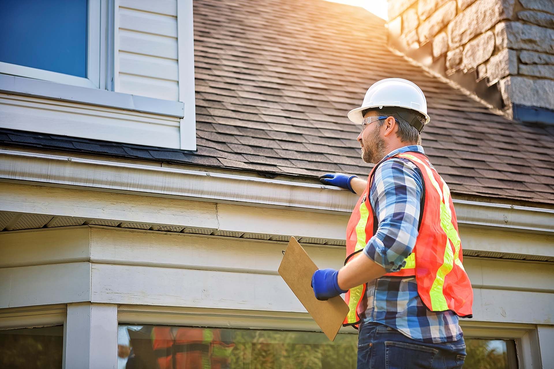 A man is inspecting a roof.