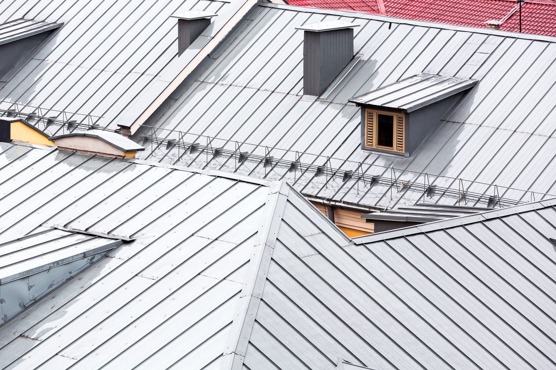 Metal rooftops with chimneys and dormer windows.