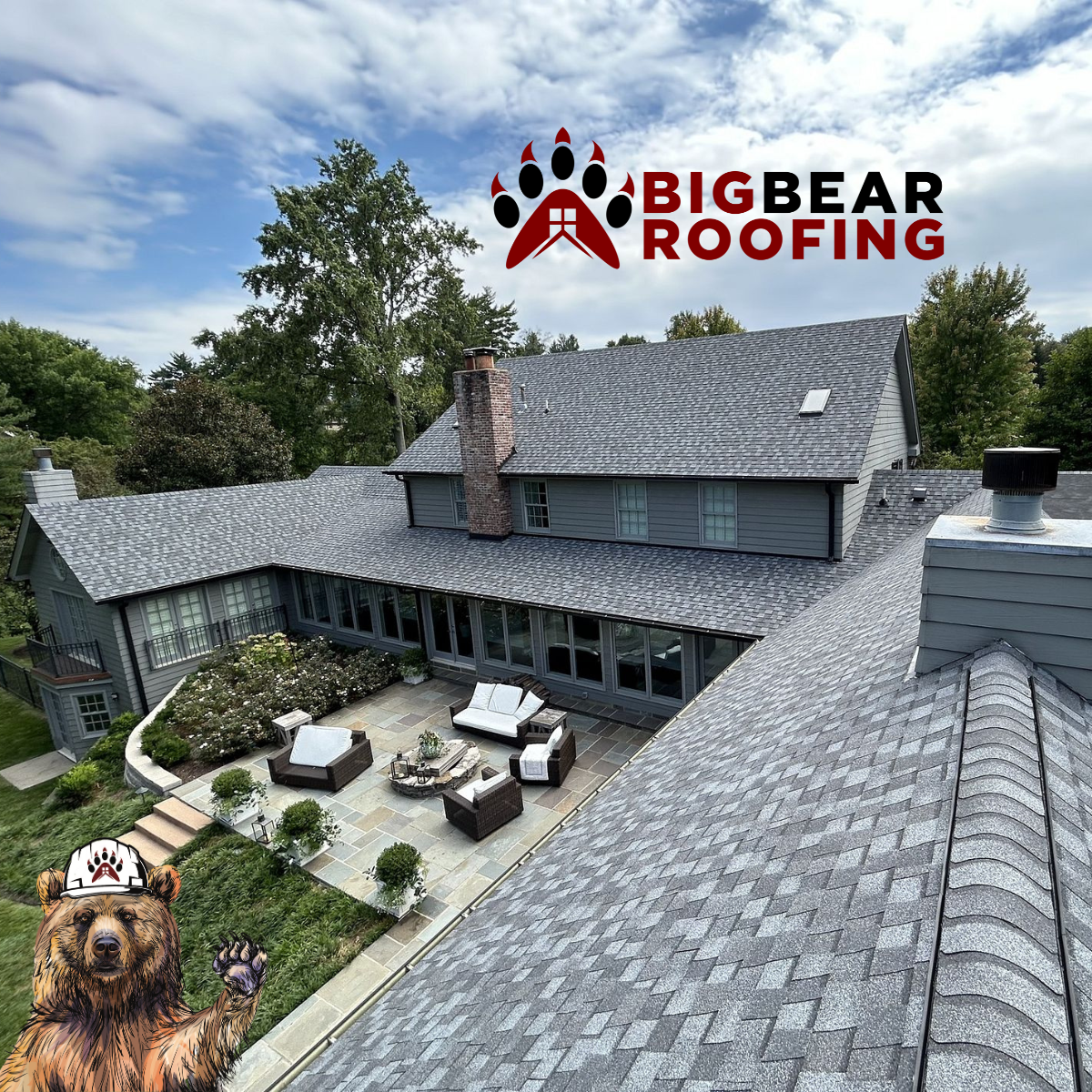 A rooftop view of a gray house with a patio, trees, and