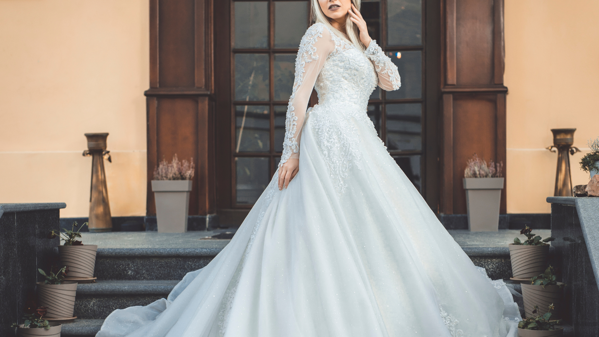 A woman in a wedding dress is standing on the steps of a building.
