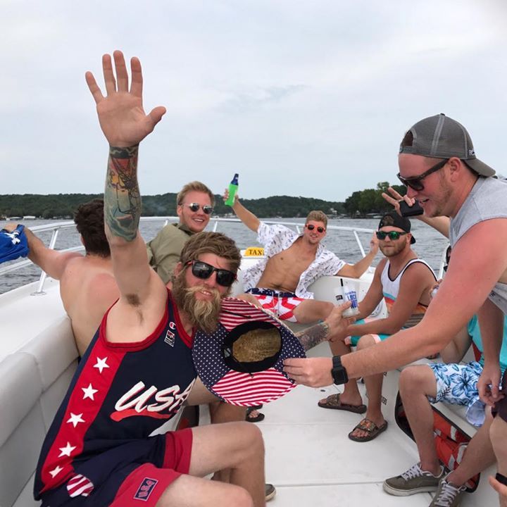 bachelor party posing on water taxi while underway